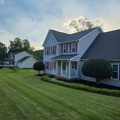 Two-story home with a freshly mowed lawn and trimmed beds at dusk in the Upstate of SC